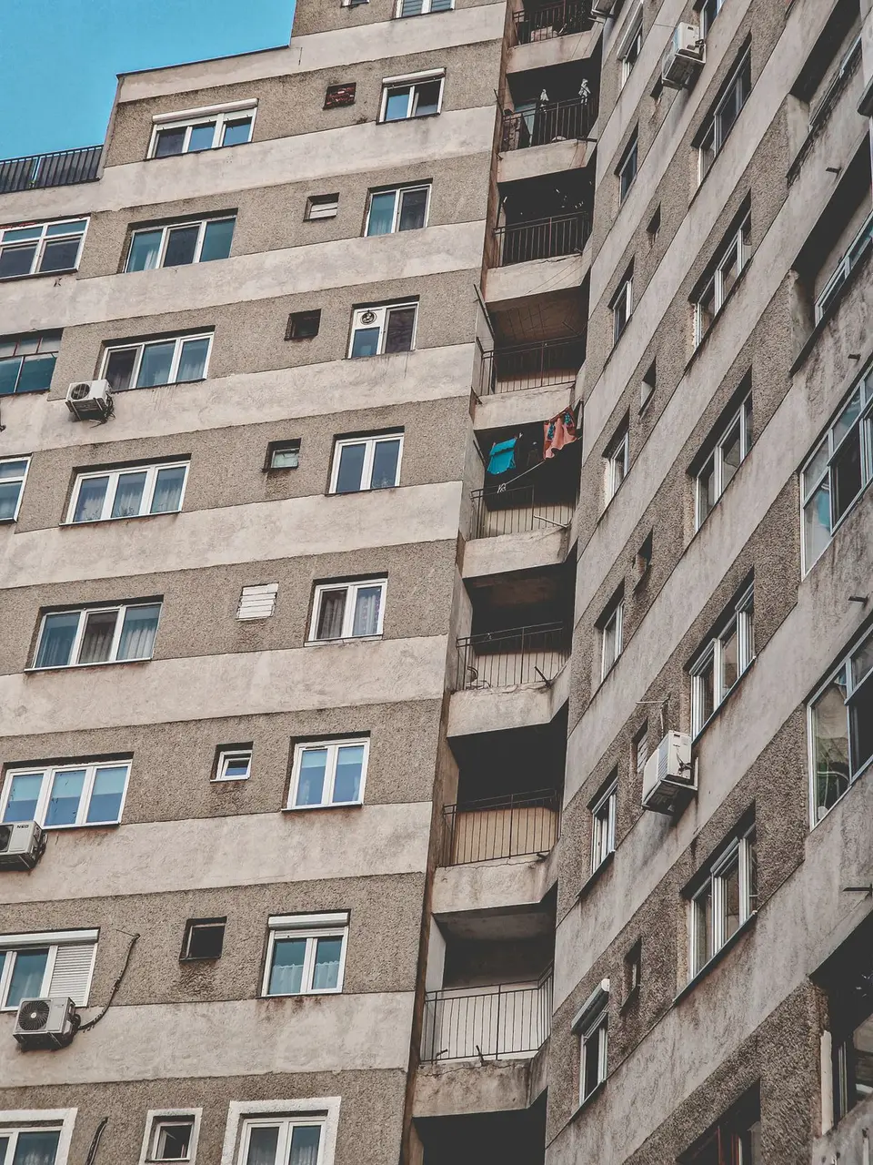 High-rise residential building with balconies and multiple windows in an urban setting.