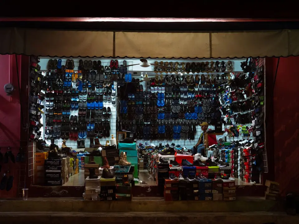 Explore Bacalar's vibrant night market with this bustling shoe store filled with colorful footwear.